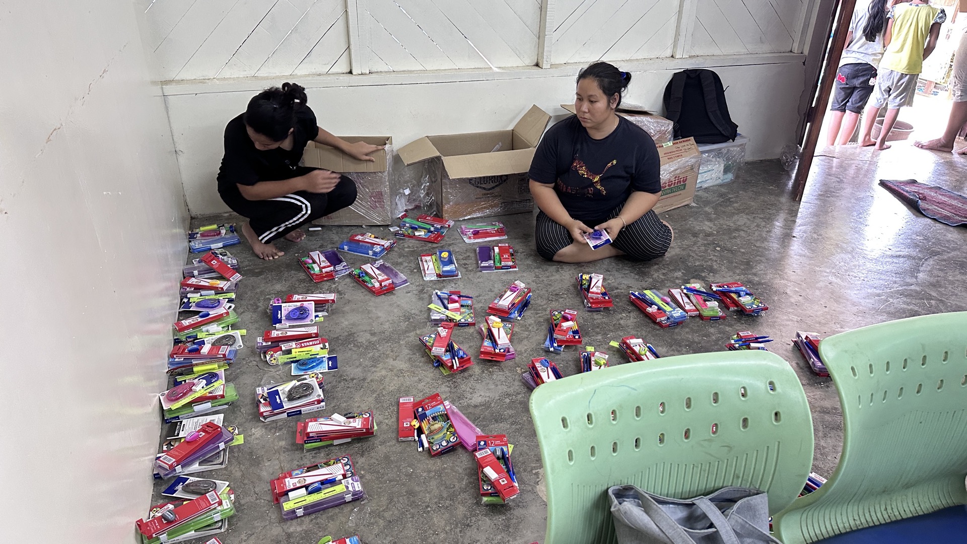 Village educator guiding young Orang Asli learners through hands-on exercises at a community learning centre