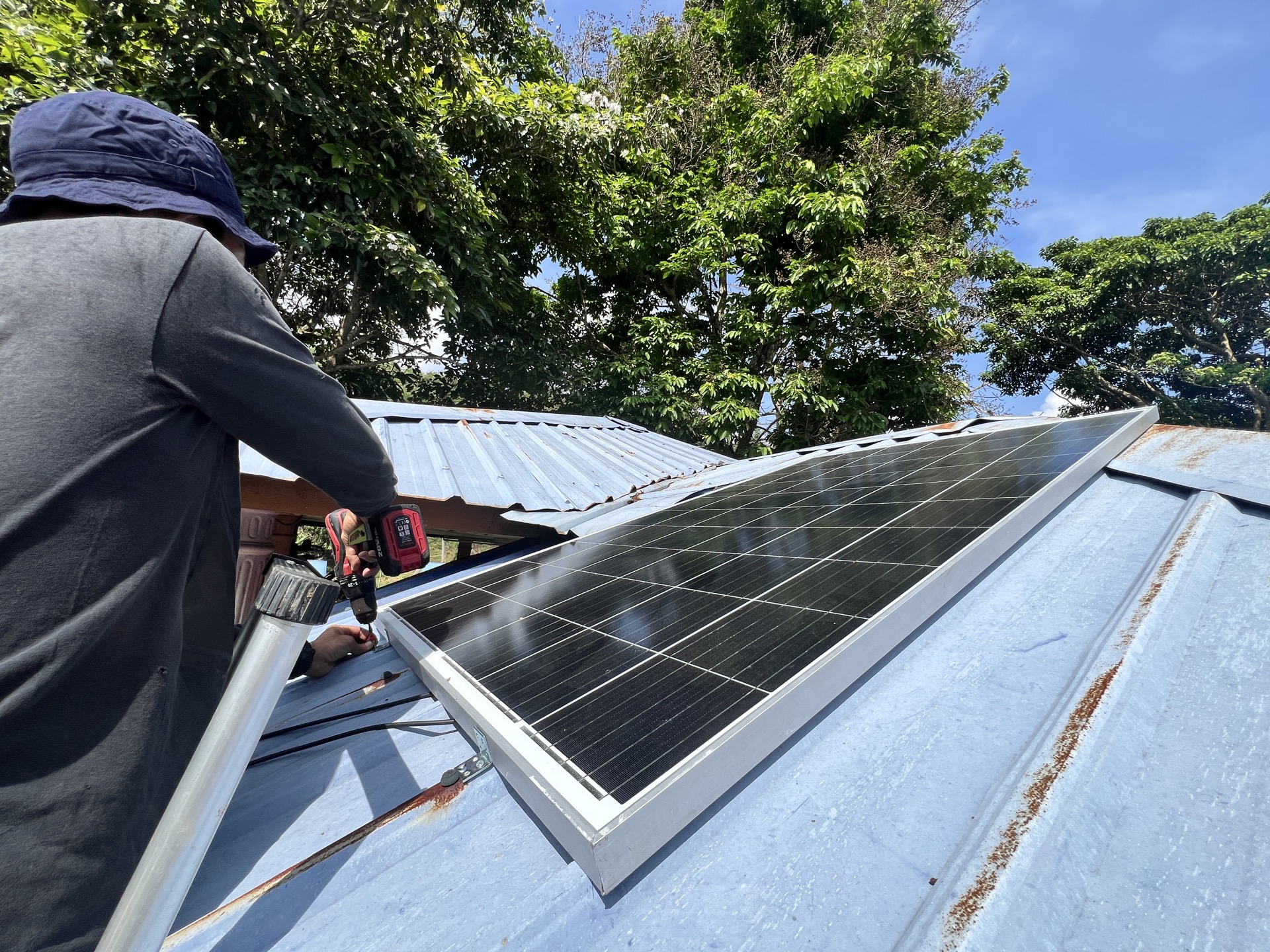 Orang Asli village at dusk illuminated by solar-powered lighting, replacing kerosene lamps